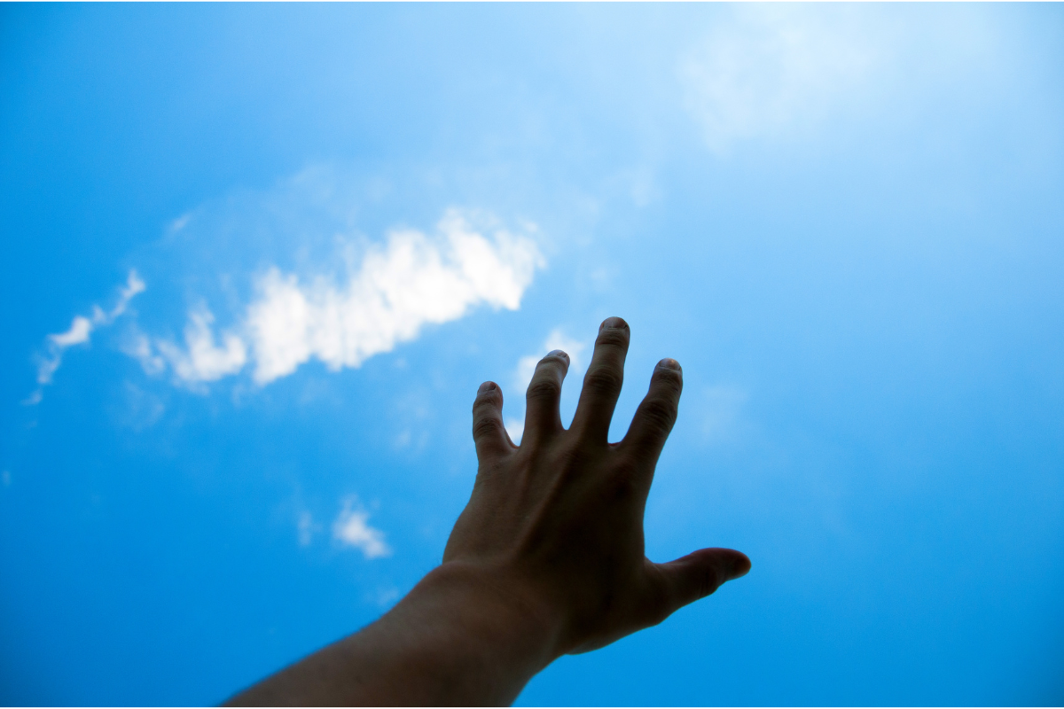 An image of a hand reaching for the sky.