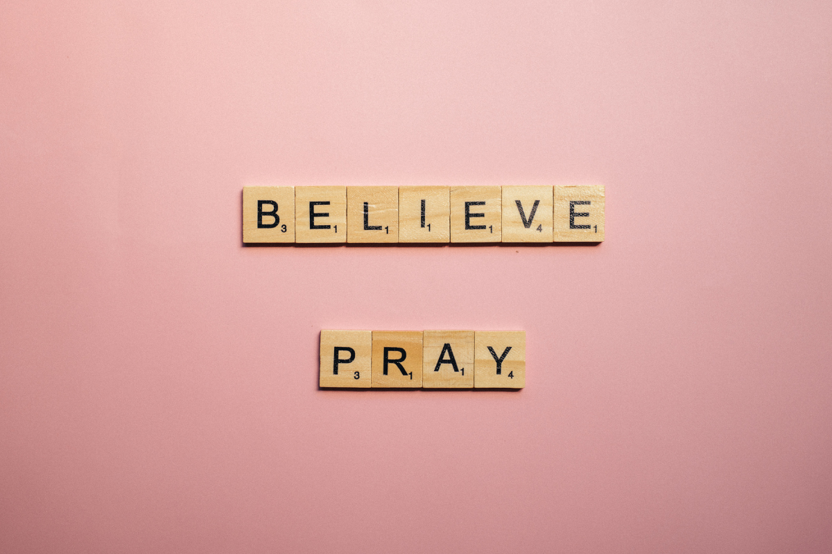 Scrabble tiles with the words Believe and Pray.