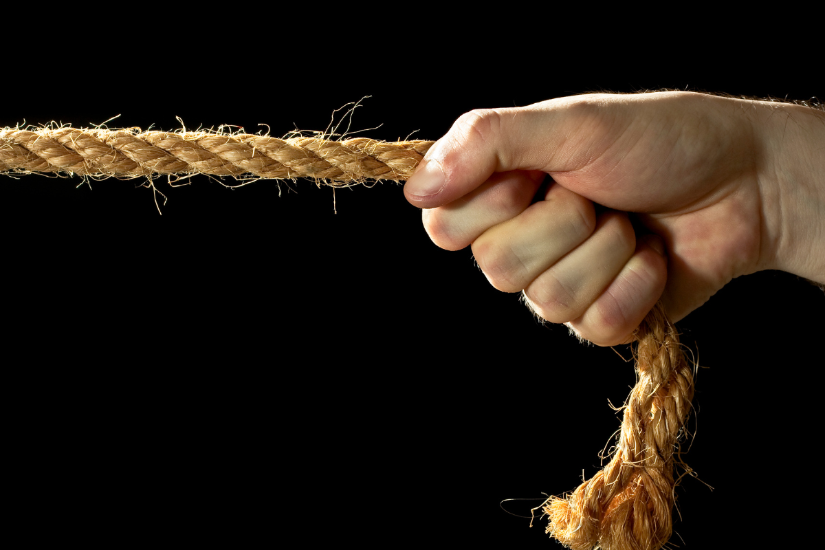 An image of a hand pulling on a rope.