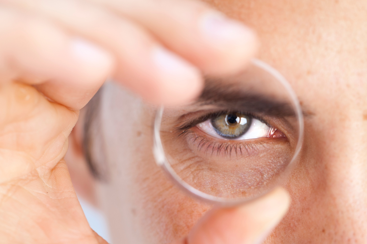 A man looking through a single lens.