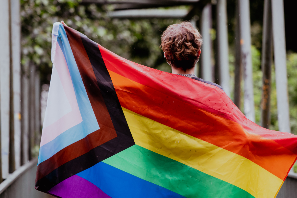 An image of a person holding a Pride flag.