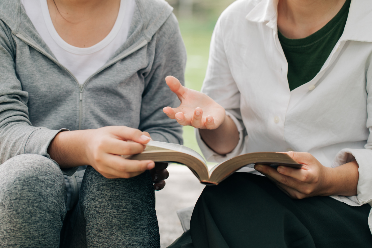 An image of two people discussing the content of the Holy Bible.