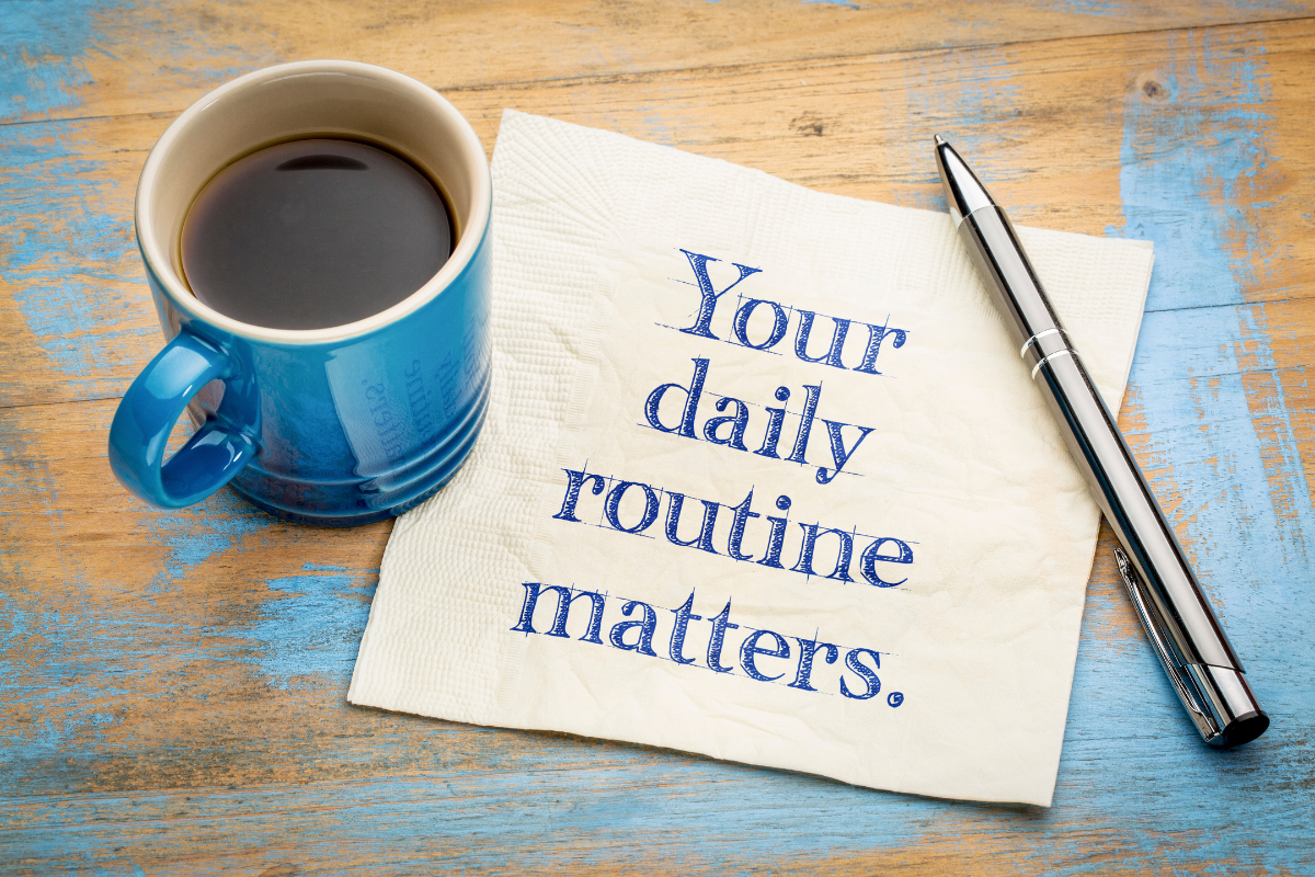 An image of a paper with something written on it, alongside a pen and a blue mug.