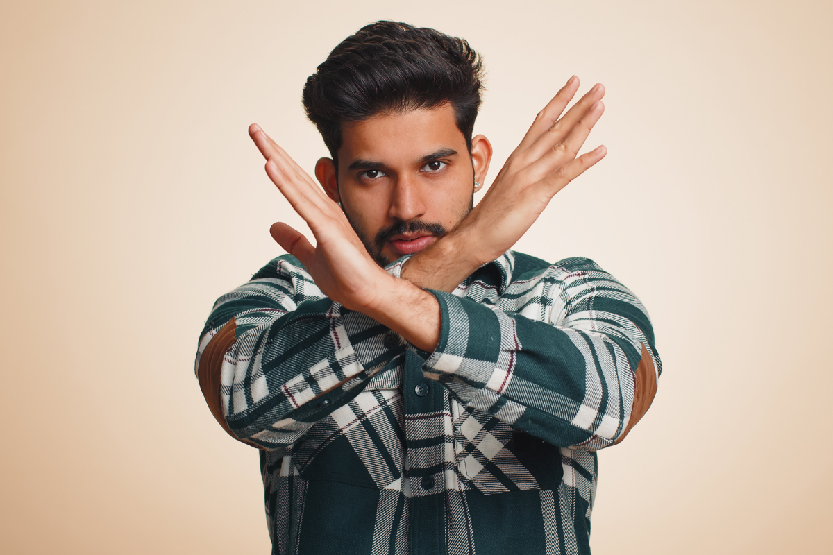 A man doing to the 'X' or 'No' hand gesture.