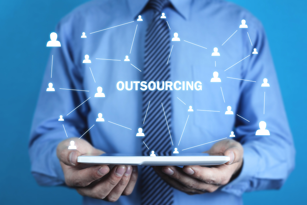 An image of a man holding a laptop, depicting outsourcing in business.